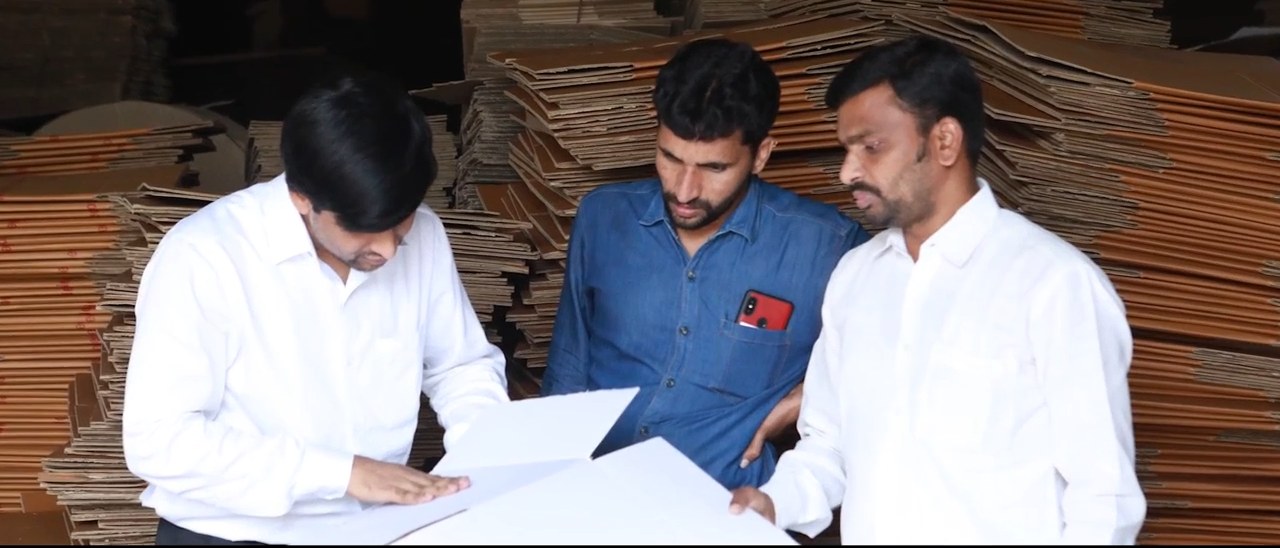 Managers reviewing a specification beside stacked board at a Bollant unit